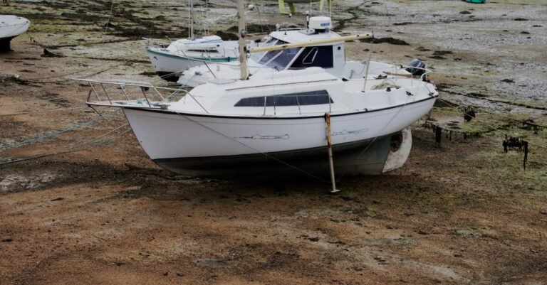 Sailboats standing on dry land at low tide with their hulls and waterlines fully exposed