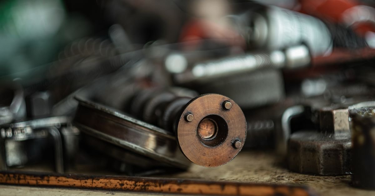 Close-up of small machined metal components laid out on a workshop surface