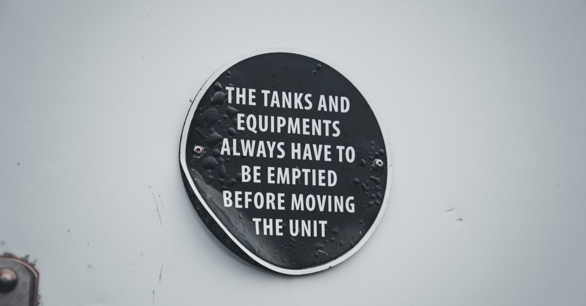 Close-up of a warning and identification plate riveted to industrial equipment