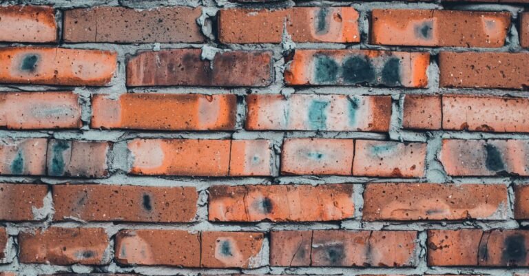 Weathered red brick wall with visible mortar joints that require low-pressure cleaning