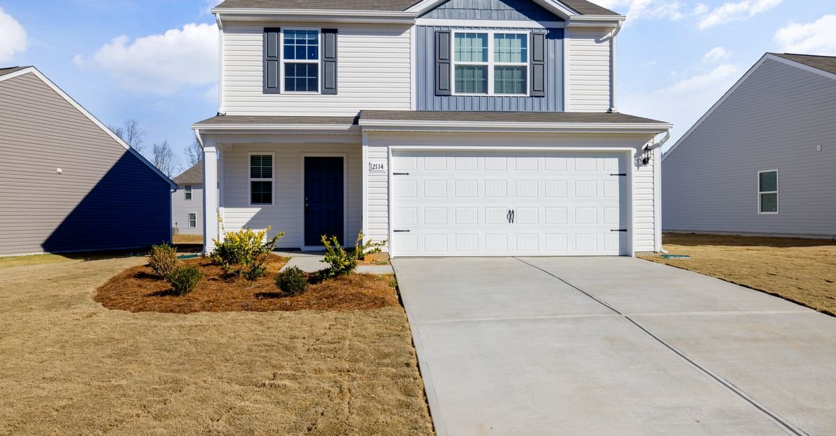 Clean vinyl-sided house with a concrete driveway