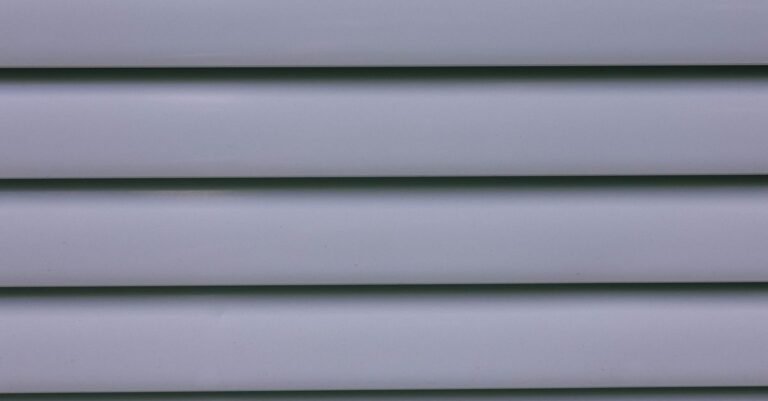 Close-up of overlapping gray vinyl siding panels showing the lap profile