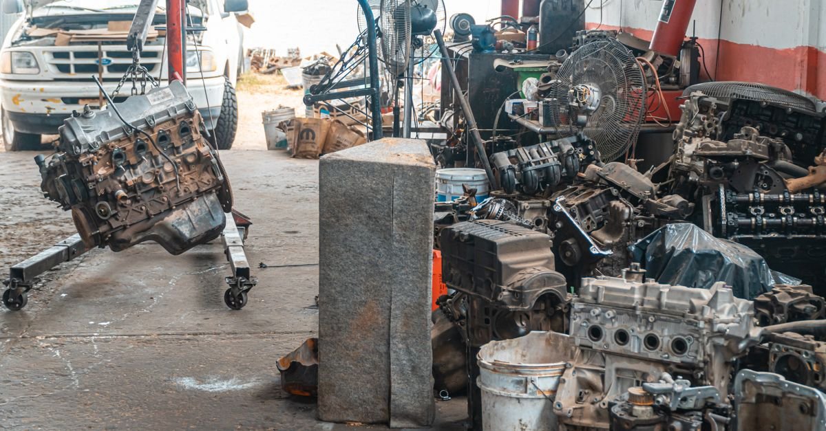 Auto workshop displaying a collection of engine parts and repair equipment laid out on a bench