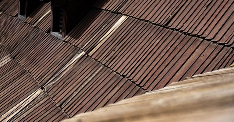 Aged cedar shingles laid in overlapping courses across a steep roof slope