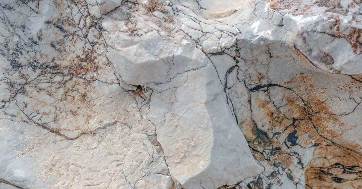 Weathered marble surface showing the natural veining and open texture that acid etching destroys