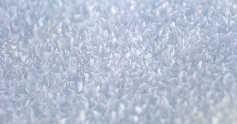 Macro shot of white crystalline granules catching the light, the form citric acid is sold in