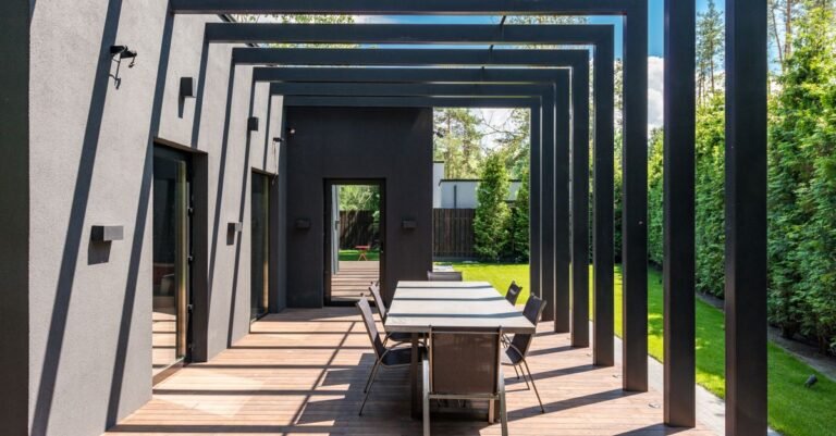 Contemporary patio with an open-topped timber pergola standing over an outdoor dining table and chairs