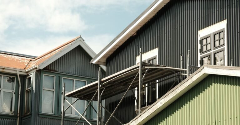 A row of houses clad in brightly painted corrugated metal siding on a clear day