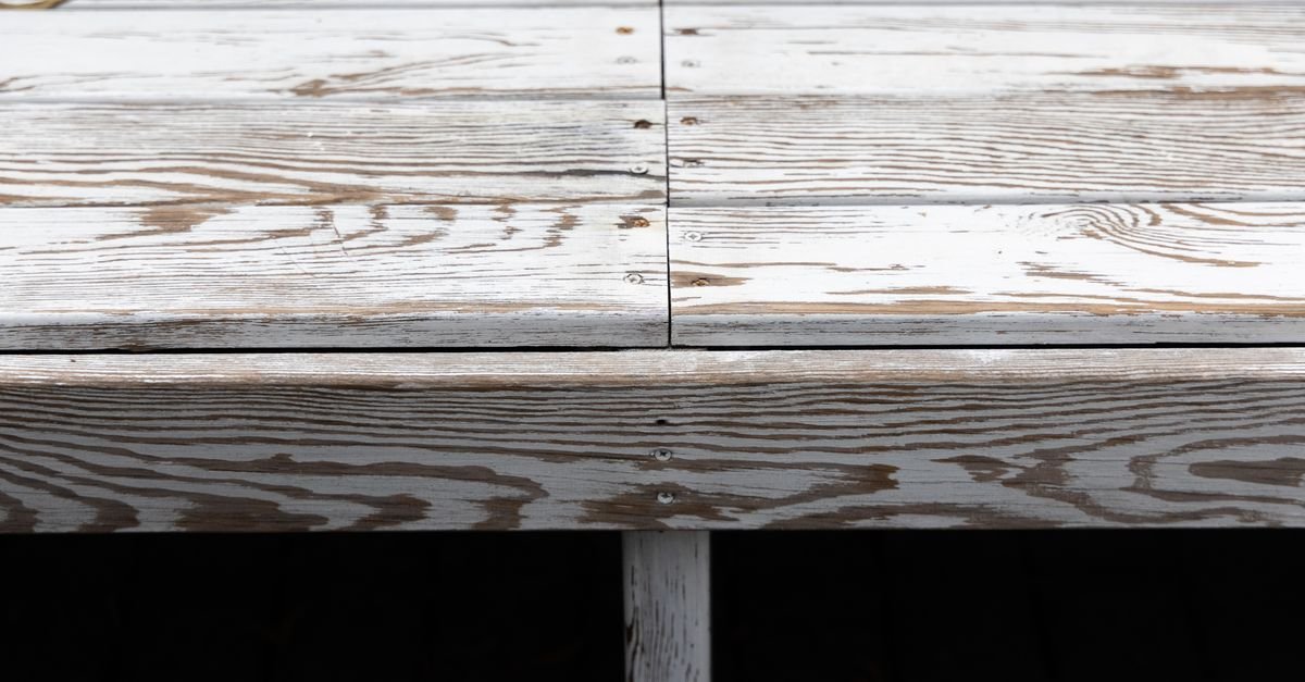 Aged deck boards with steel screw heads, the fixings that leave the dark iron stains a brightener is meant to lift