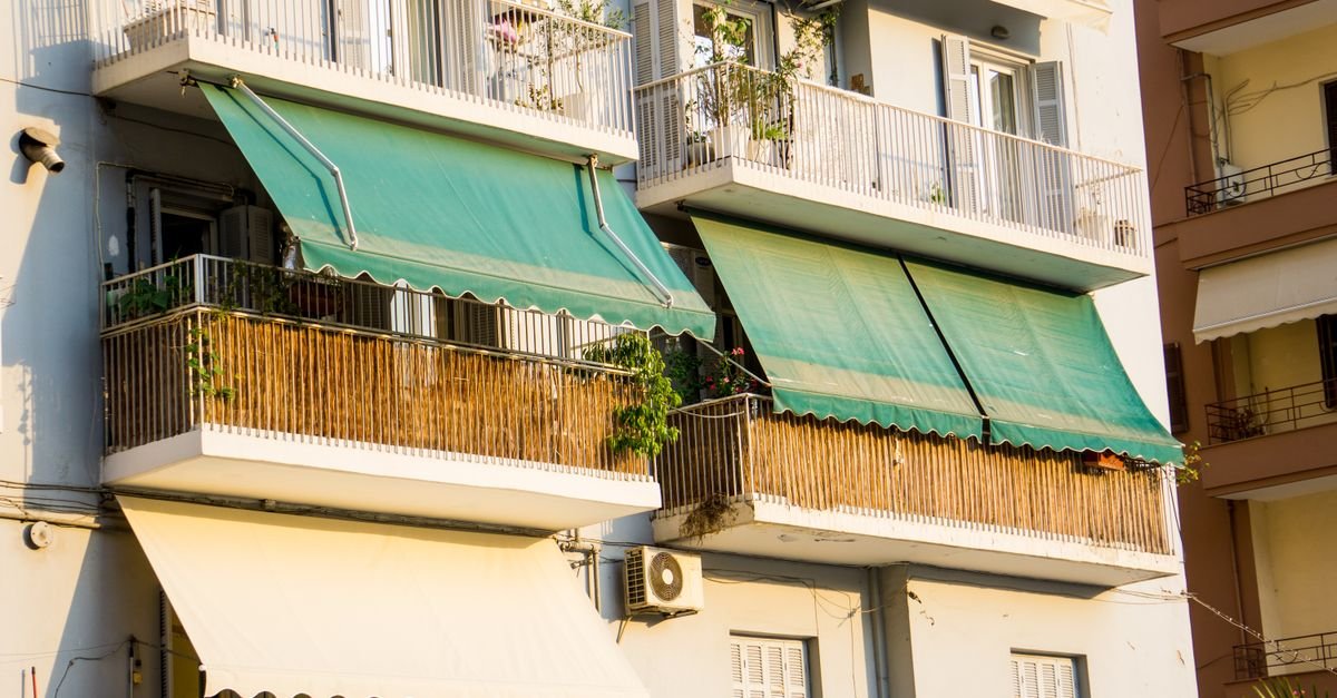 Close-up view of balconies with green awnings seen from below in Thessaloniki, Greece