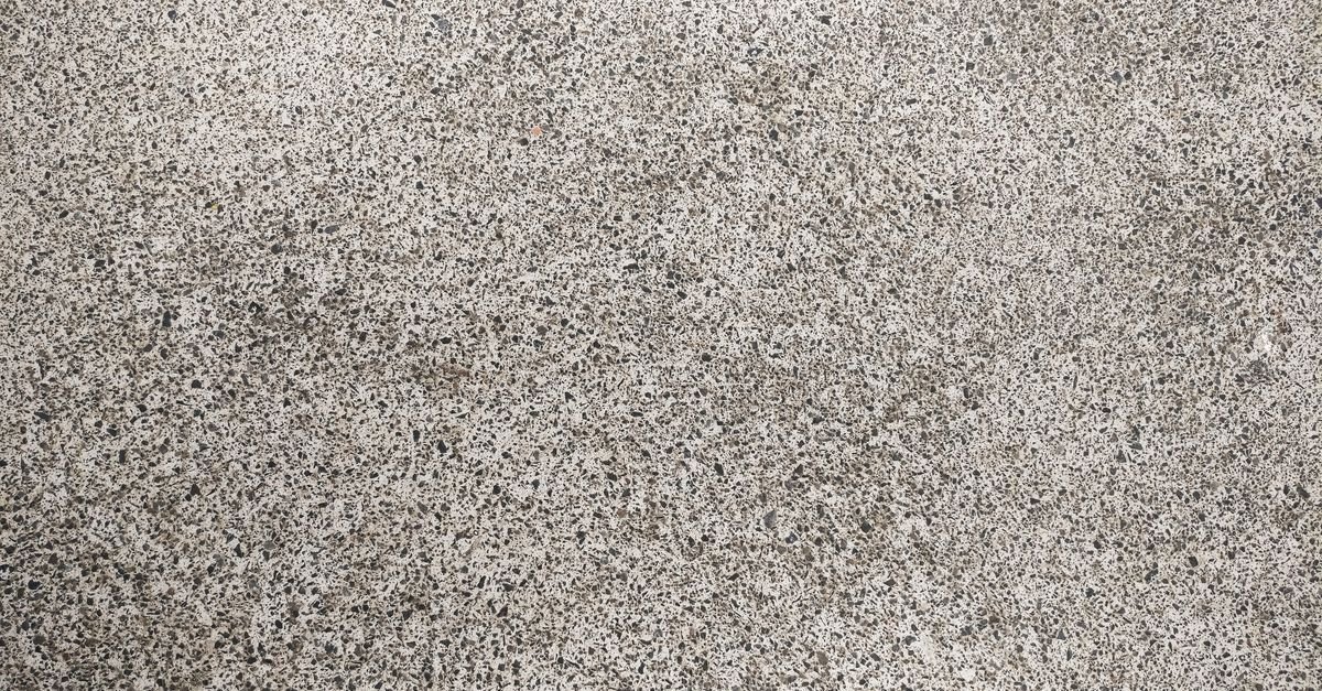 Close-up of a bare grey concrete surface showing its open, porous texture