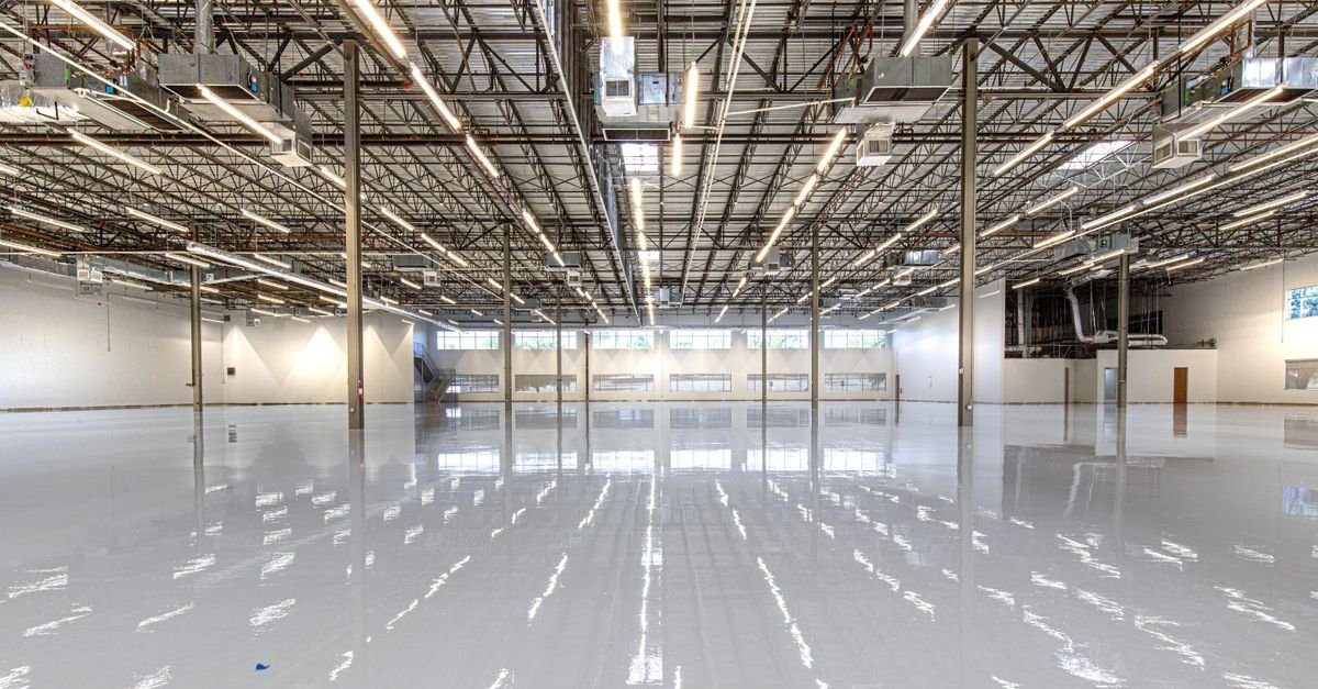 Large interior with a glossy epoxy-coated concrete floor reflecting overhead lights