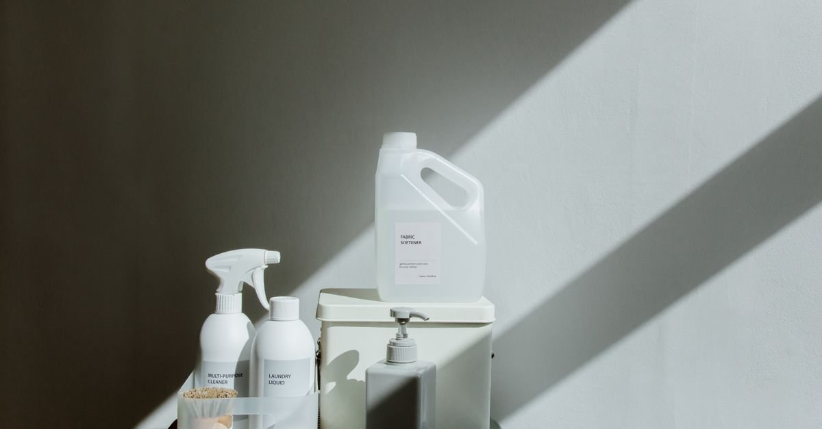 Household cleaning bottles arranged on a shelf under hard directional light