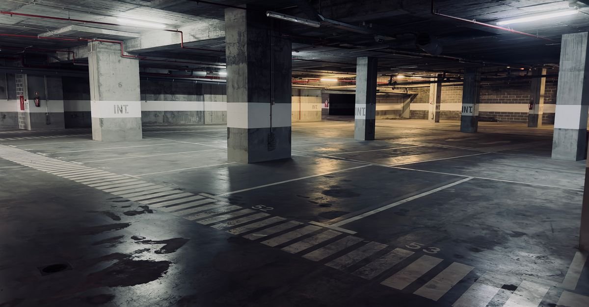 Standing water pooling across a flat concrete garage floor with nowhere to drain