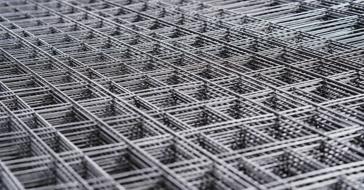 Close-up of a fine woven steel wire mesh grid showing the aperture between the wires
