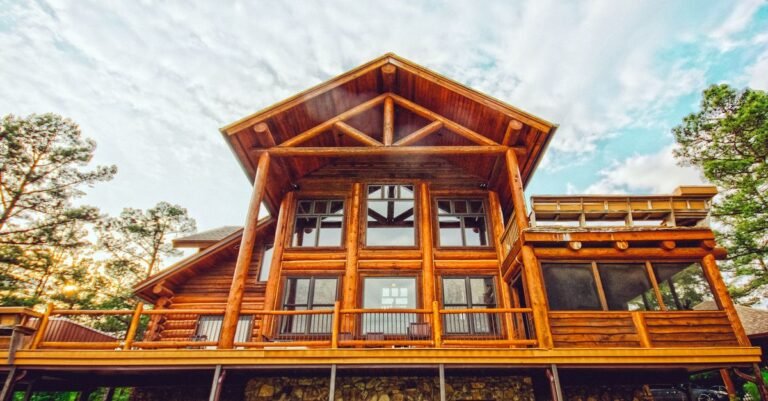 A log cabin exterior with exposed horizontal log courses and large glass windows