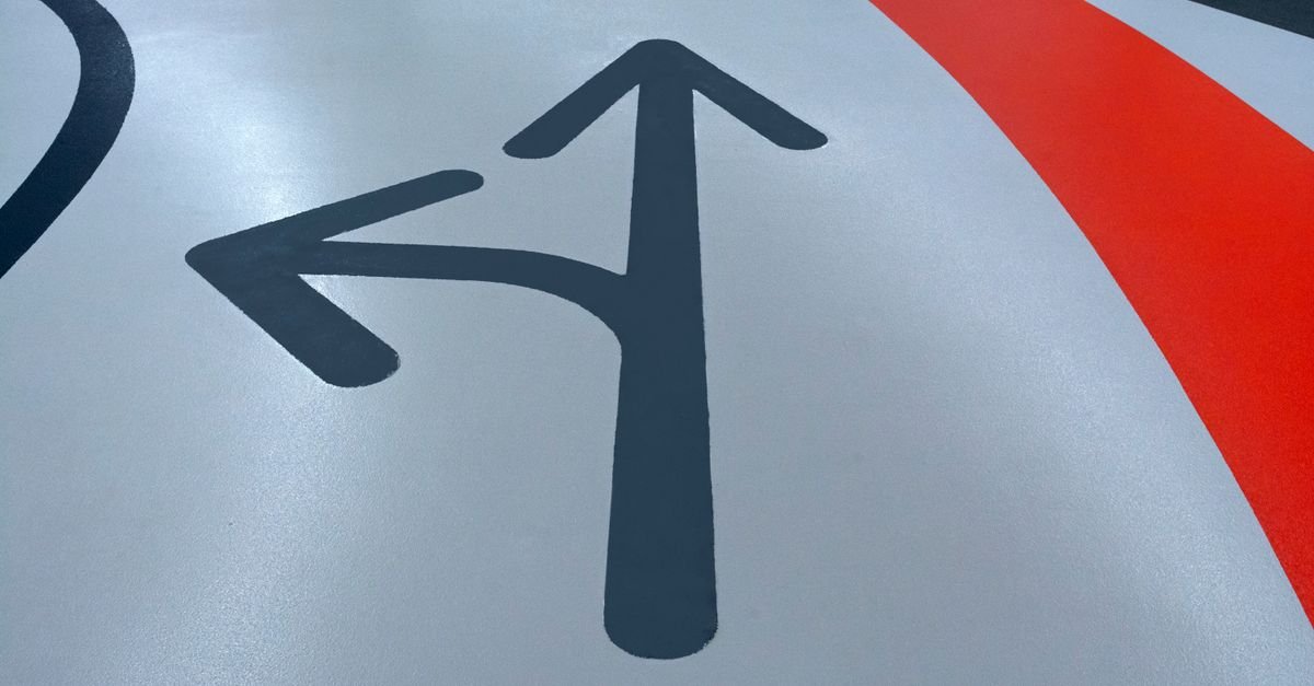 Painted directional arrows on a parking garage floor, an example of concrete coating that is doing its job and does not need stripping