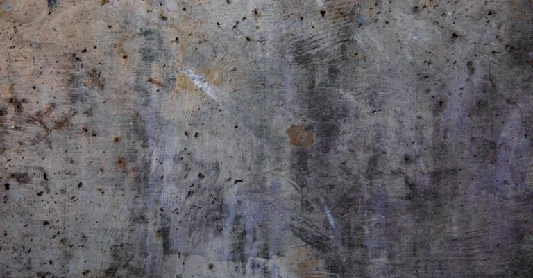 Orange rust staining spread across a rough weathered concrete surface