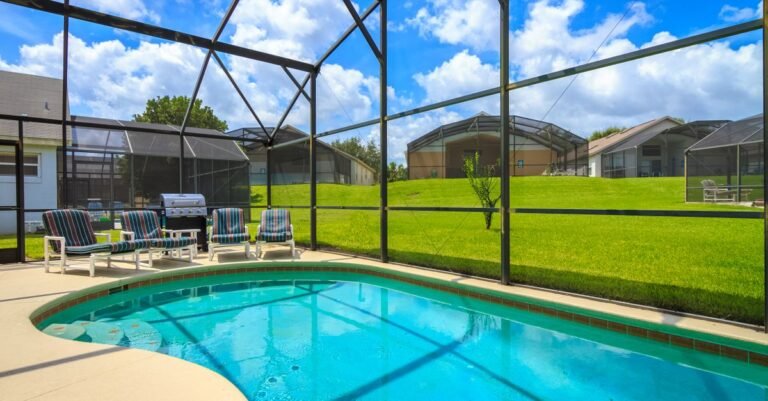 Screened pool enclosure at a Florida villa with lounge chairs and a grill inside the cage