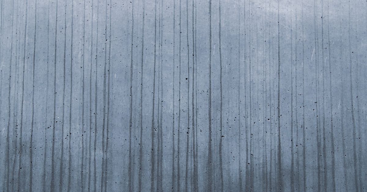 Vertical streaks running down a pale wall where liquid has drained and dried in place
