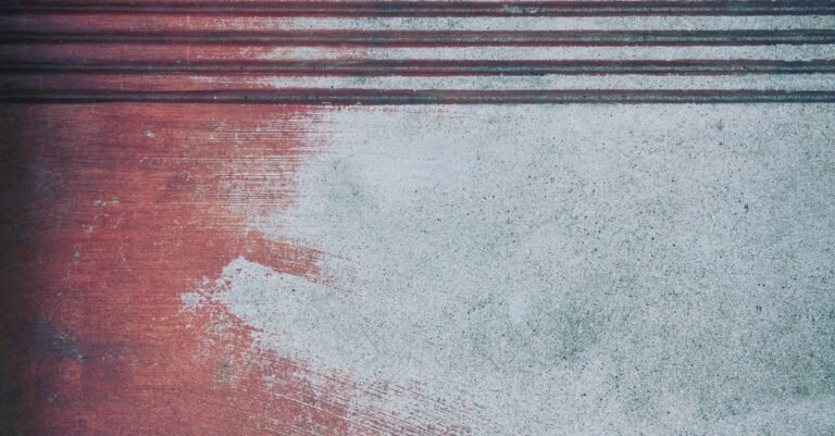 Close-up of a concrete slab with reddish discolouration spreading through the surface texture