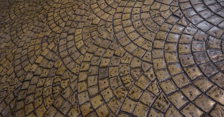 Patterned decorative paving laid in an intricate circular design with deep joints between the units