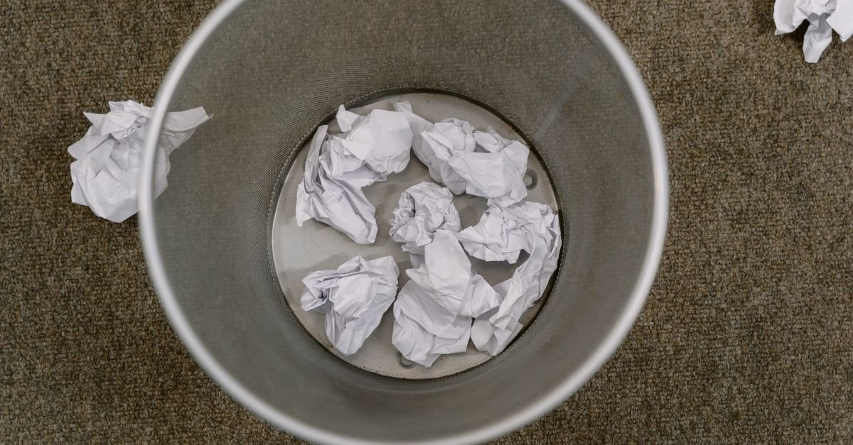 Overhead view down into a trash can, showing the inner wall and base of the container