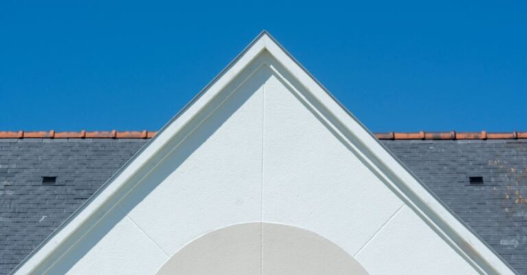 Sunlit slate-look roof tiles photographed close up against a clear blue sky