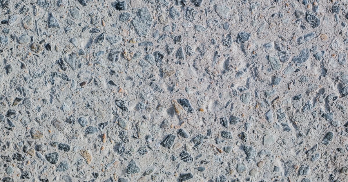 Concrete surface where the cement paste has worn away to expose the sand and stone aggregate beneath