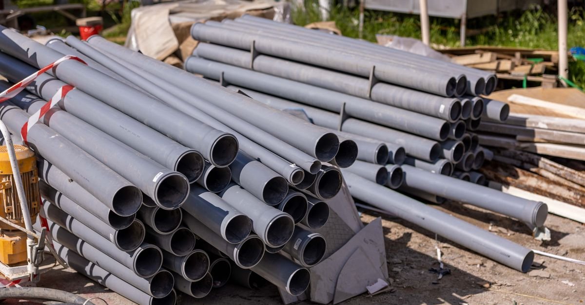 Grey PVC pipes of several bores stacked at a construction site, showing how much the internal diameter changes