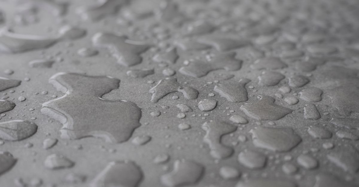 Water beading on a grey surface, the visible sign that a sealer is still repelling water