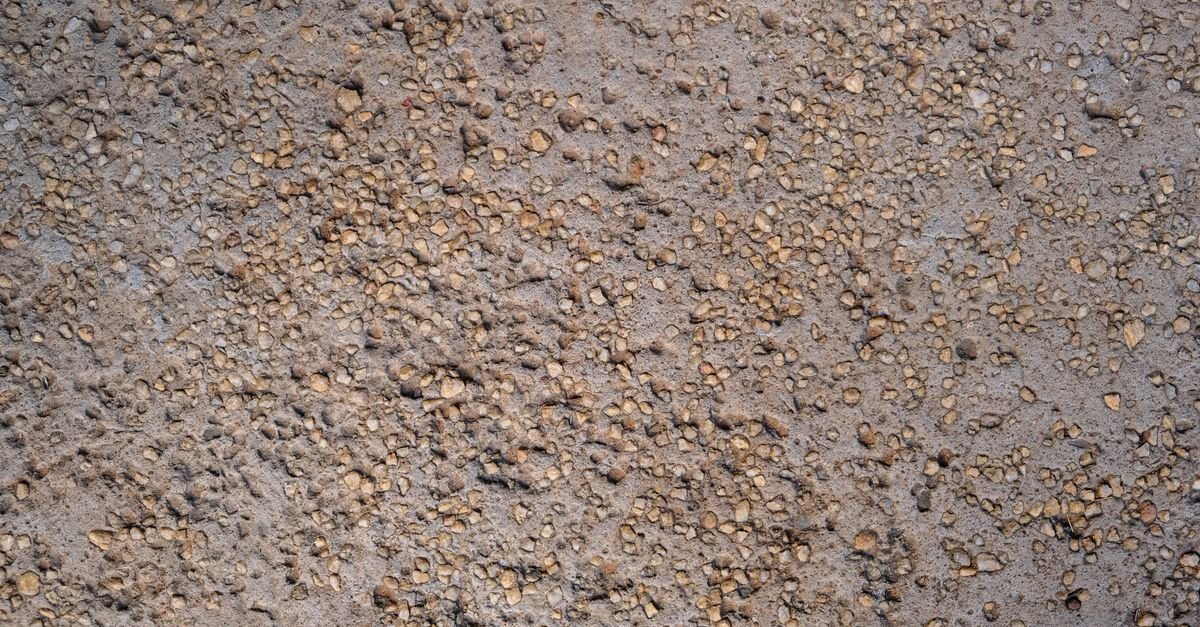 Close-up of an asphalt surface showing individual stones held in the dark bitumen binder