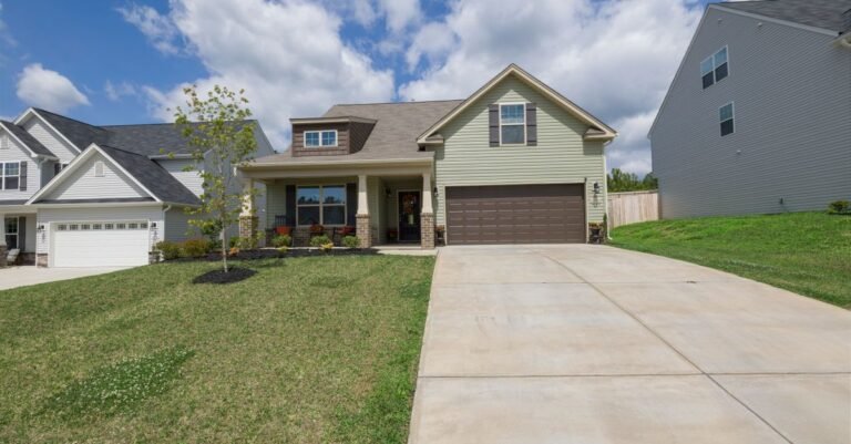 Modern detached house with a wide driveway running from the garage down to the street