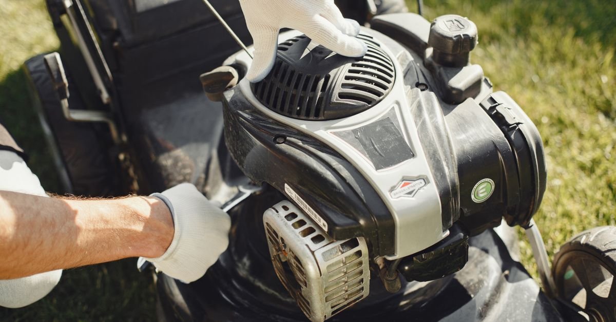 Hands performing small-engine maintenance, the oil, air-filter and spark-plug checks a gas machine requires