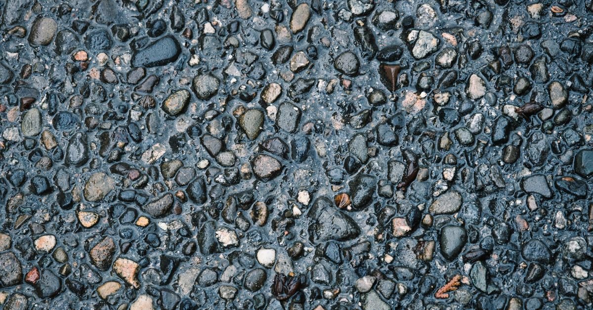 Wet pebbled pavement with water standing between the exposed stones