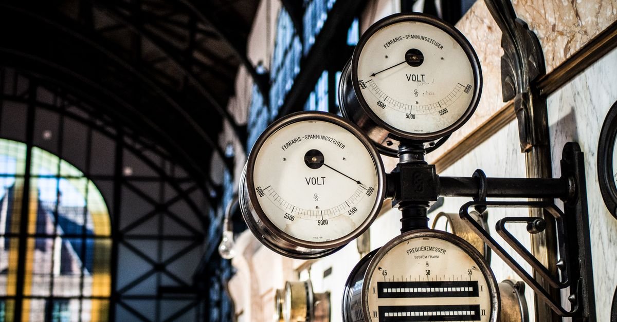 Intricate vintage volt and frequency gauges on an industrial panel, the two quantities that sag together when a motor starts on generator power