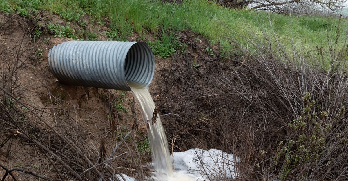 A drainage pipe discharging rainwater into a ravine well clear of any building