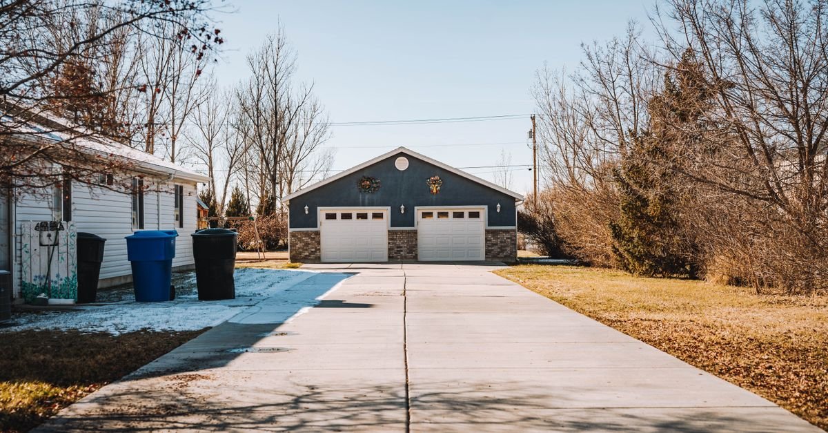 Suburban concrete driveway running up to an attached double garage
