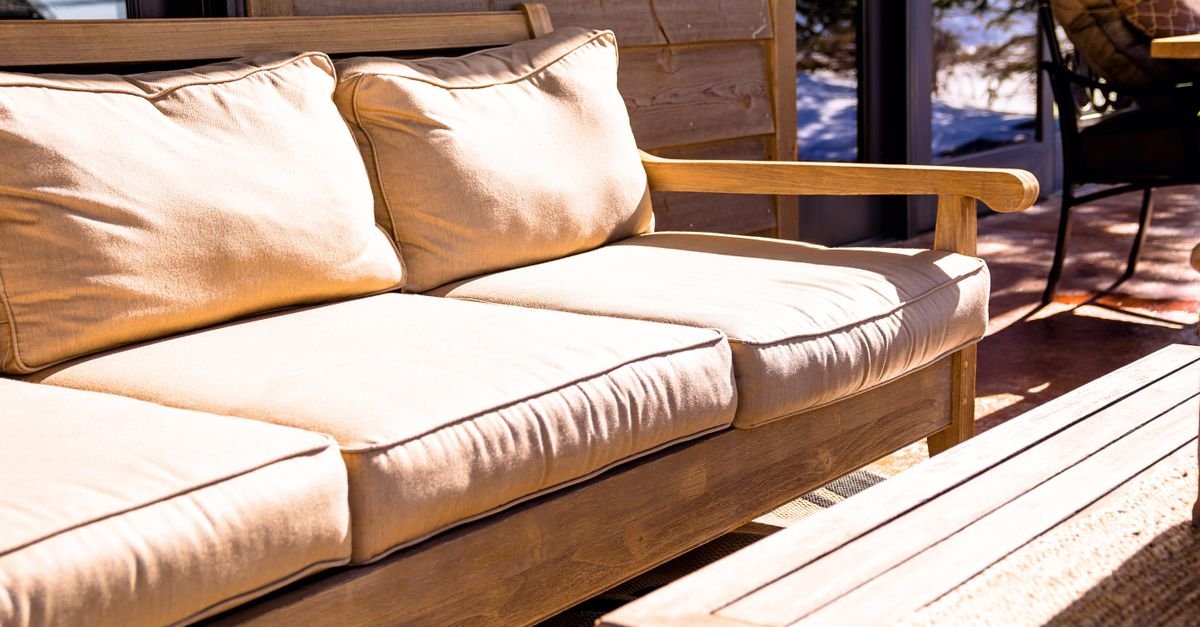 Wooden-frame outdoor sofa with thick cushions that must be removed before washing the frame