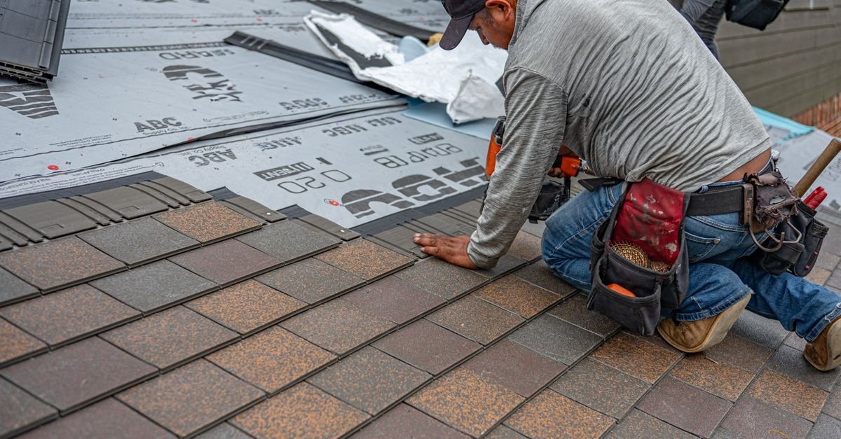 Roofer installing new asphalt shingles, showing the granulated surface before weathering