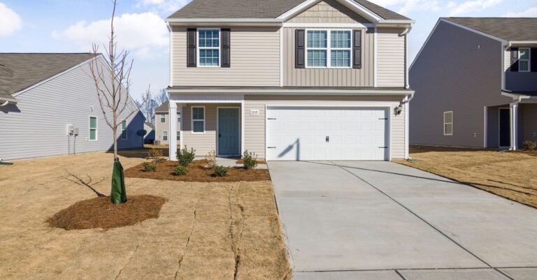 A clean concrete driveway in front of a suburban house on a dry, clear day
