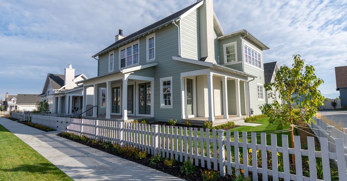 Suburban home with a clean white picket fence along the sidewalk