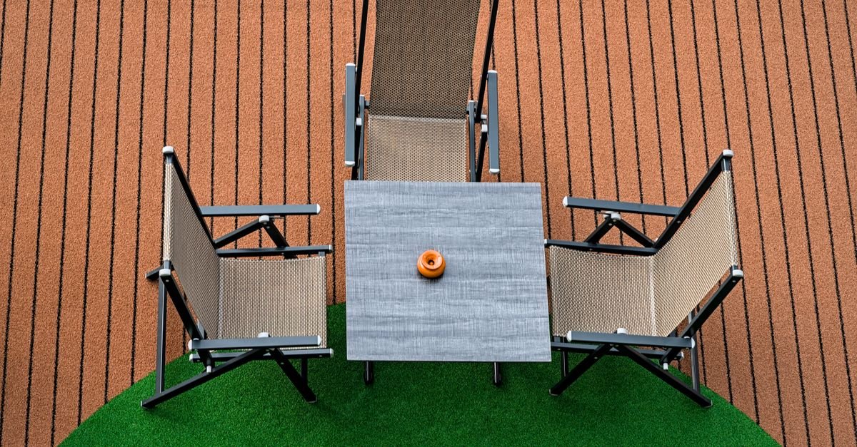 Four mesh sling chairs around a table on a terrace, seen from above