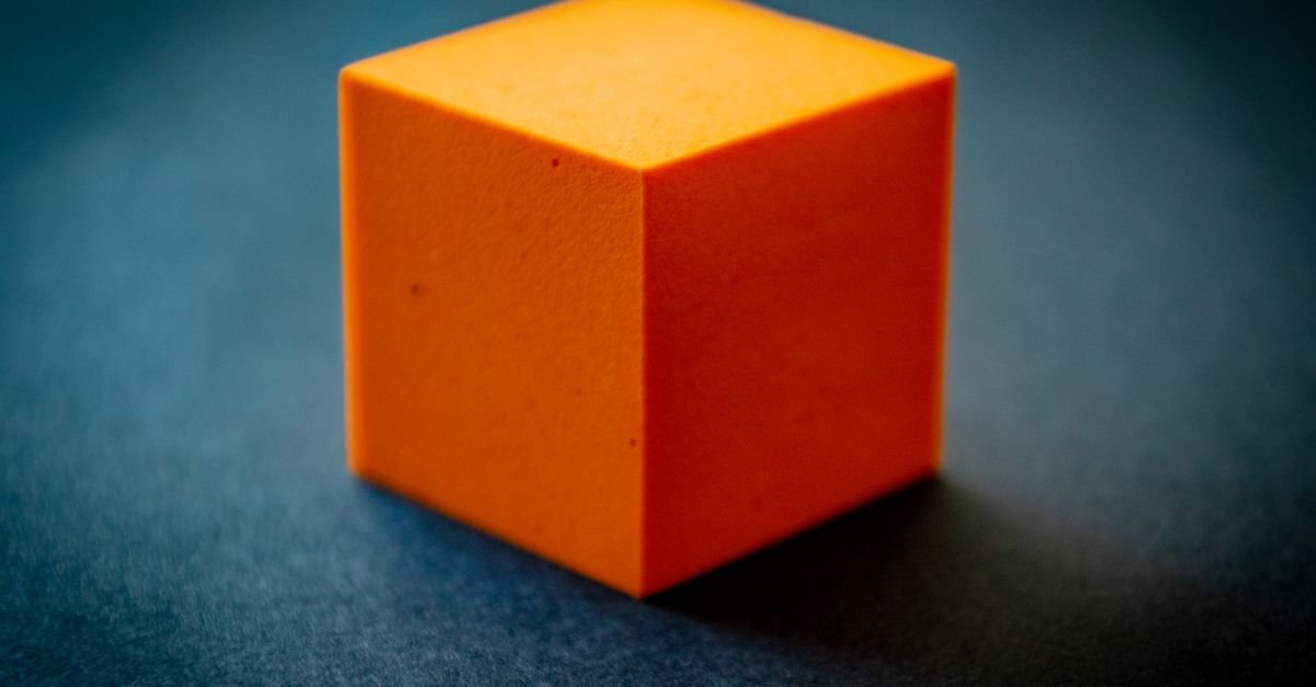 Close-up of an orange open-cell foam block showing its cell structure