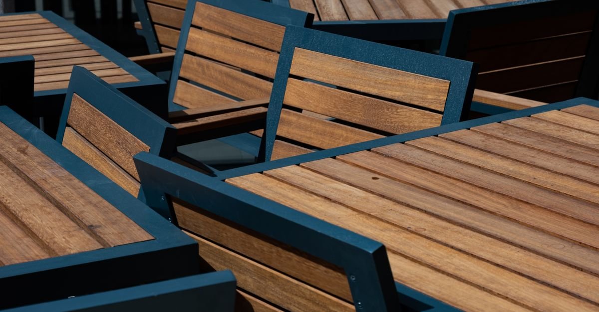 Close-up of modern outdoor wooden tables and chairs with narrow slatted tops