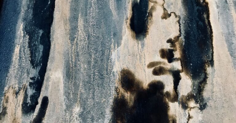 Dramatic black mold and mildew staining running down a weathered exterior wall