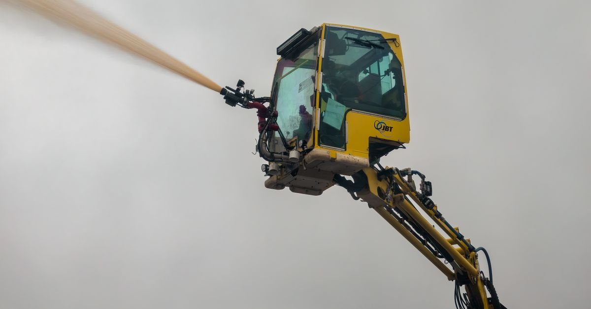 A machine throwing an arc of water into open air against a cloudy sky