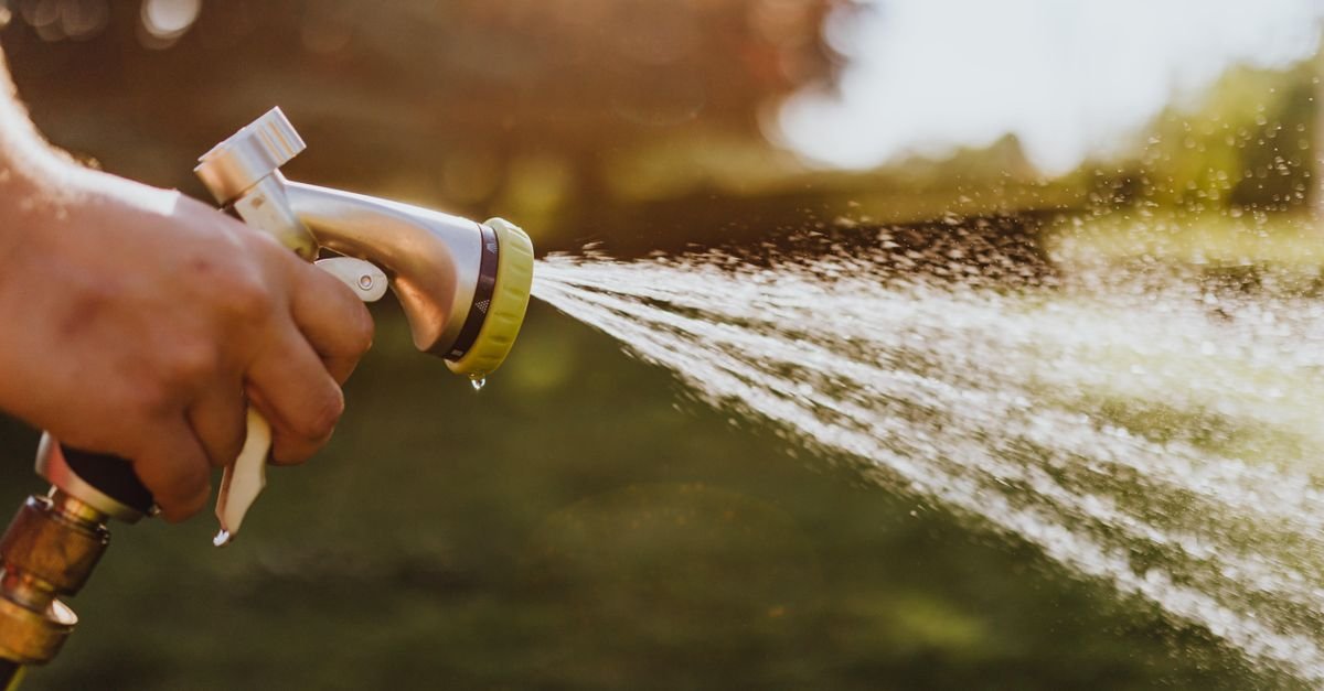 Hand holding a garden hose spray nozzle, the 40 to 70 PSI tool that already sits inside the soft wash range