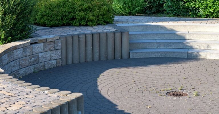 Circular stone patio with steps and planted borders in a landscaped garden