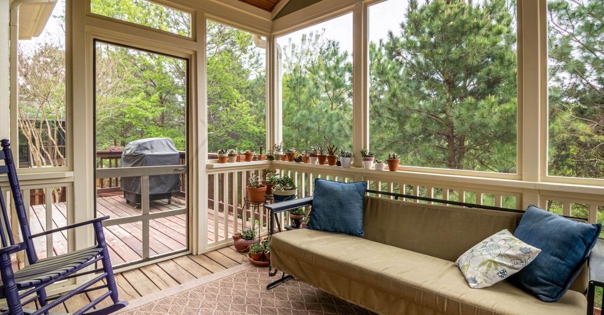 Screened porch with soft furnishings and a view through the mesh to the garden